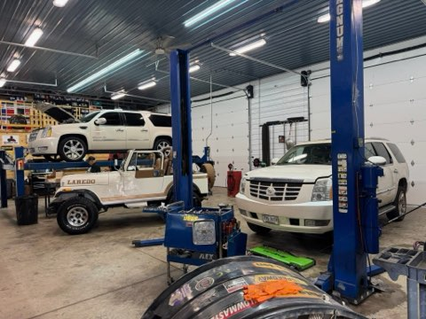 Cars on lifts in a garage; a white SUV, a Jeep, and another white SUV are visible | Chip Ragans Auto, LLC