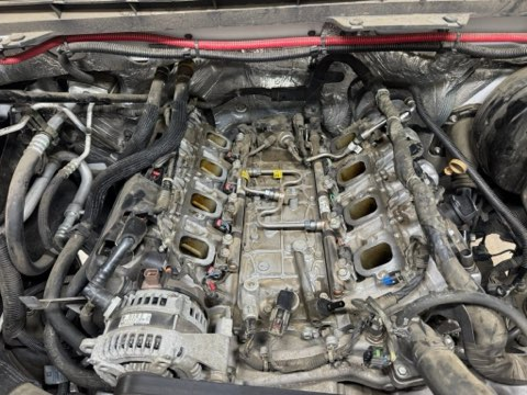 Engine bay of a vehicle with the intake manifold removed, showing the engine components and wiring | Chip Ragans Auto, LLC