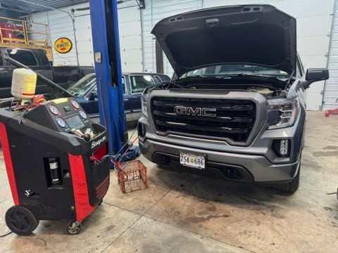 Gray GMC truck with open hood, connected to a Snap-on AC service machine in a garage | Chip Ragans Auto, LLC