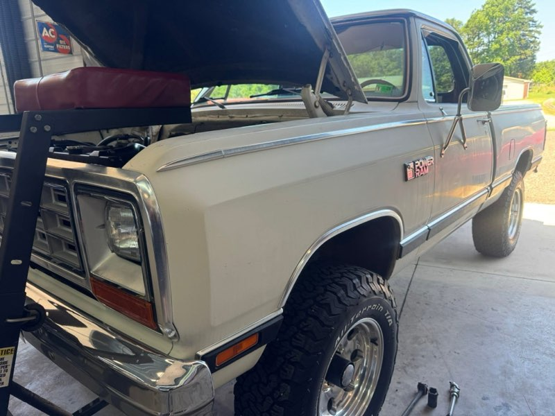White vintage Dodge Ram truck with hood open in a garage, tools visible | Chip Ragans Auto, LLC