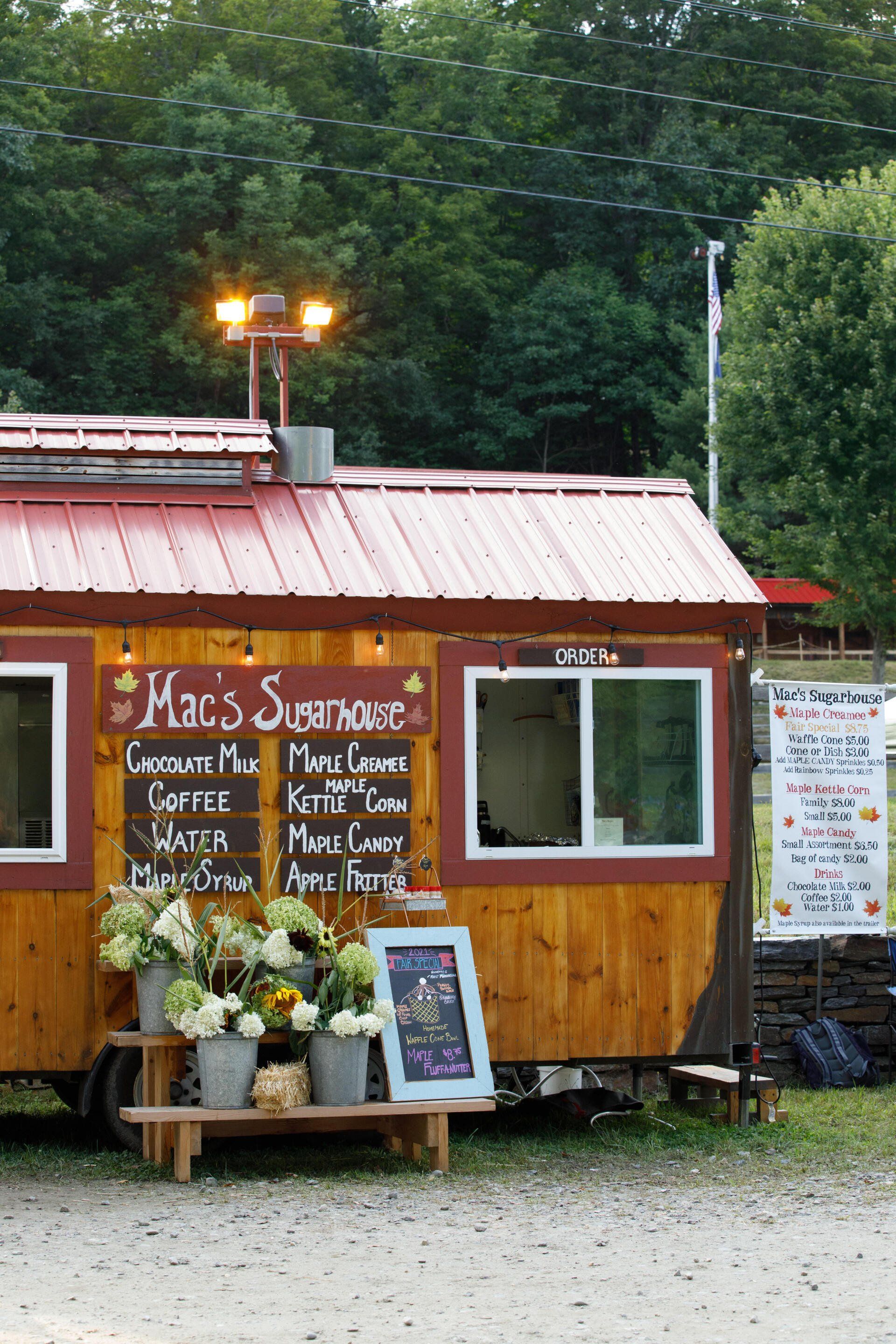 A small wooden building with a sign that says mac 's summerhouse