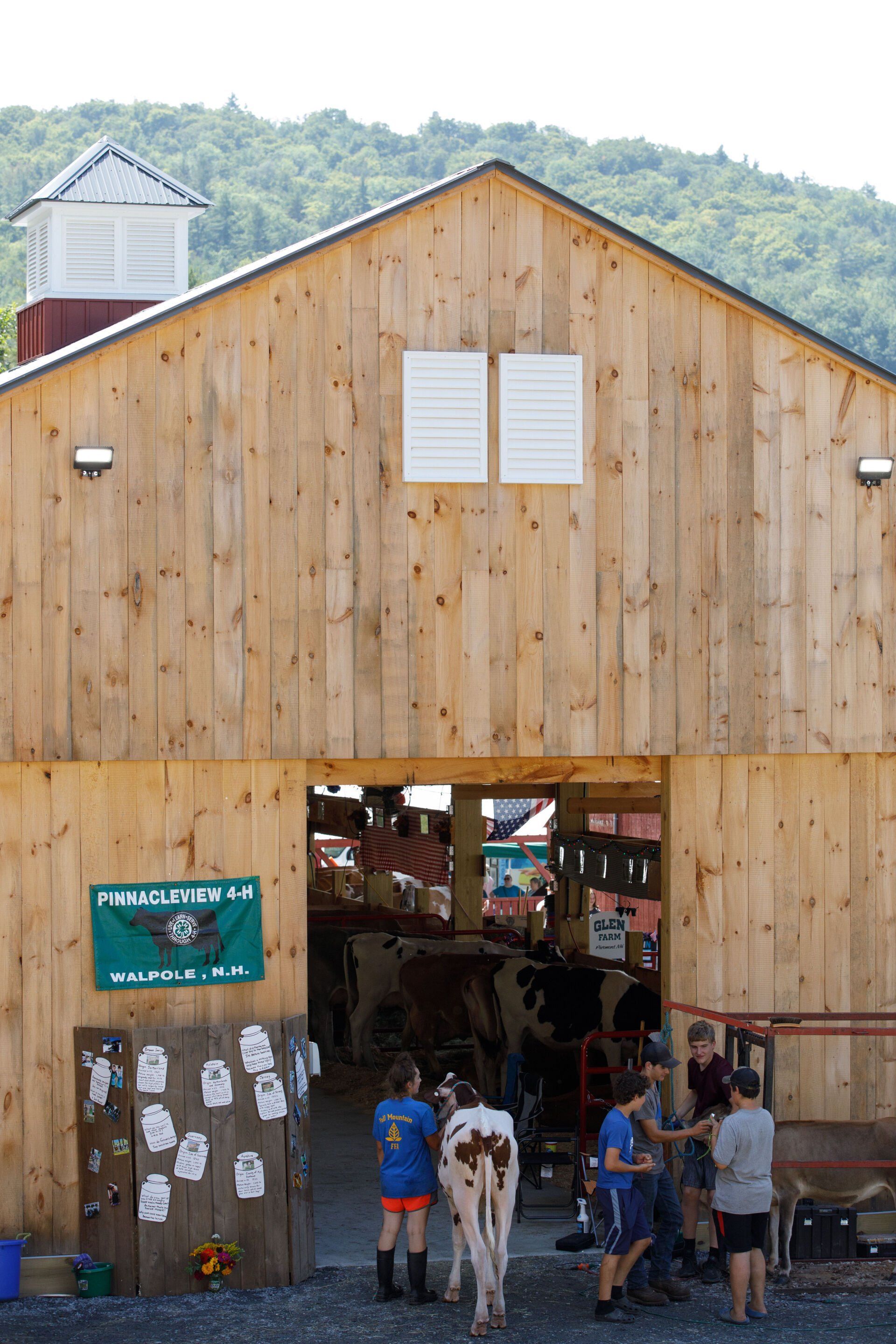 A group of people are standing in front of a wooden barn.