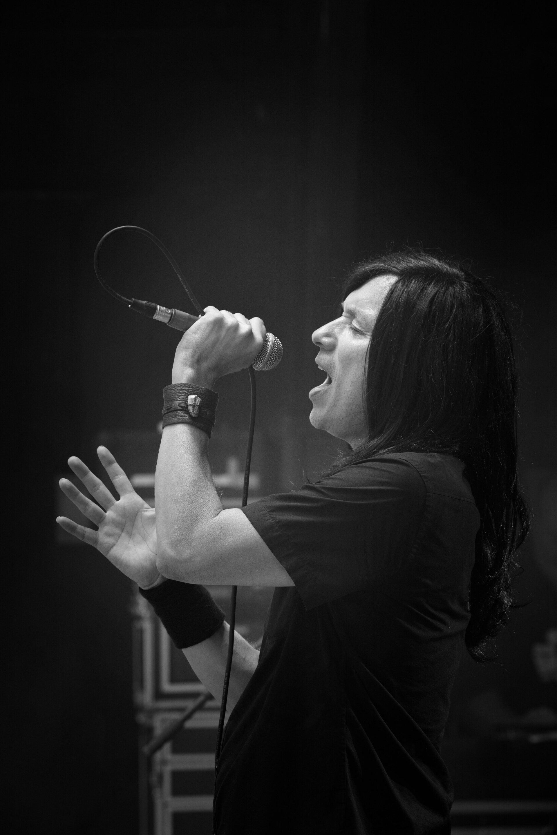 A black and white photo of a man singing into a microphone