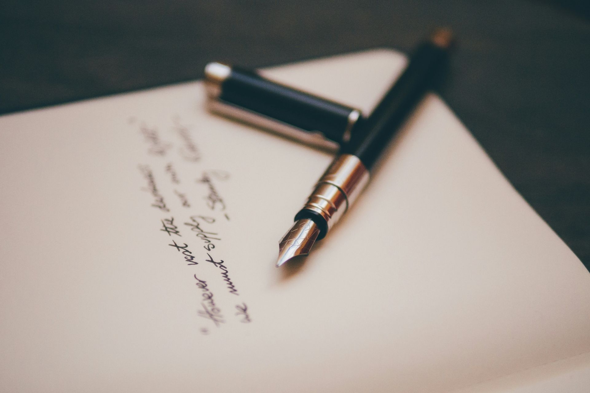 A fountain pen is sitting on top of a piece of paper.