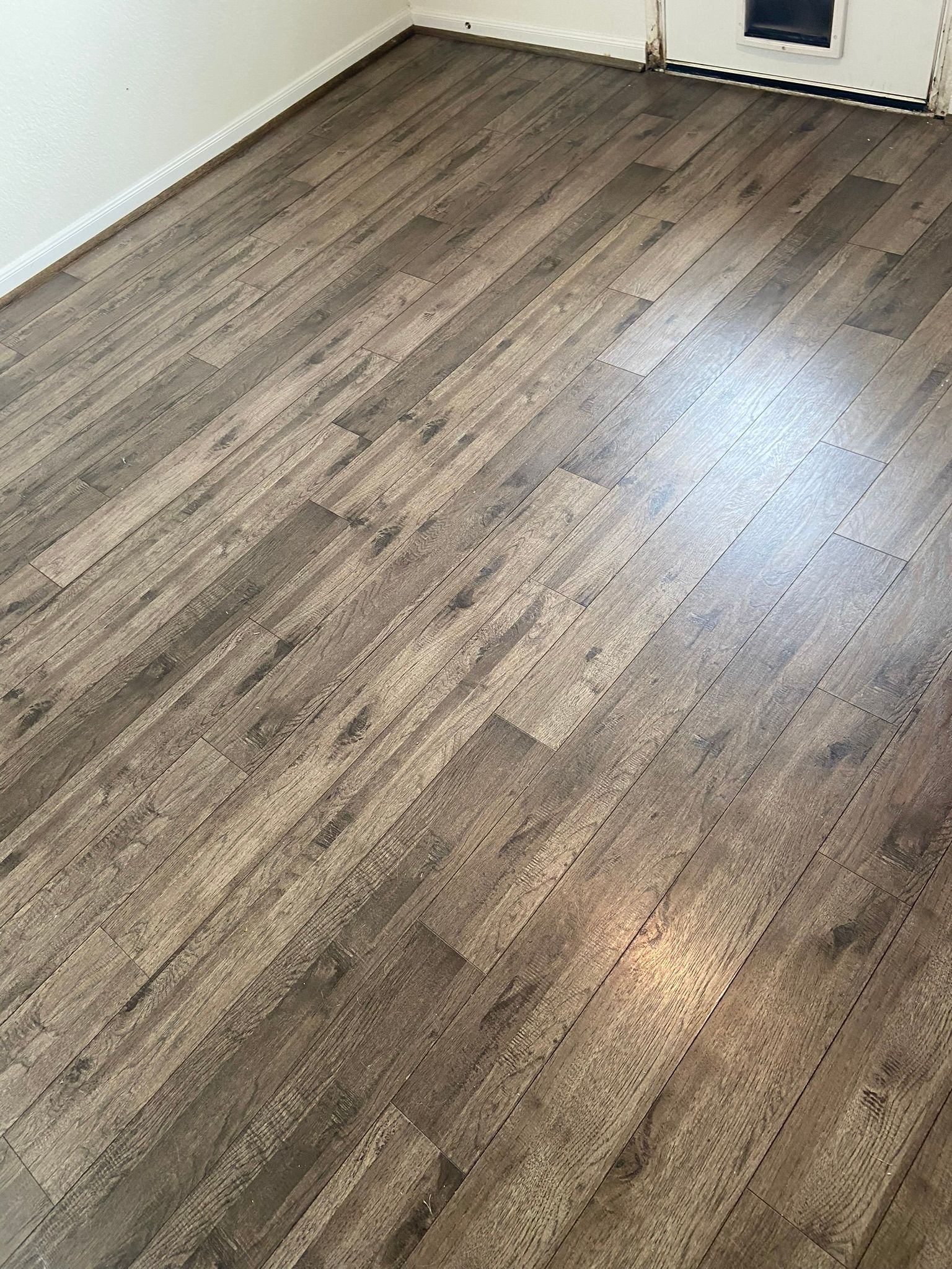 A room with a wooden floor and white walls.