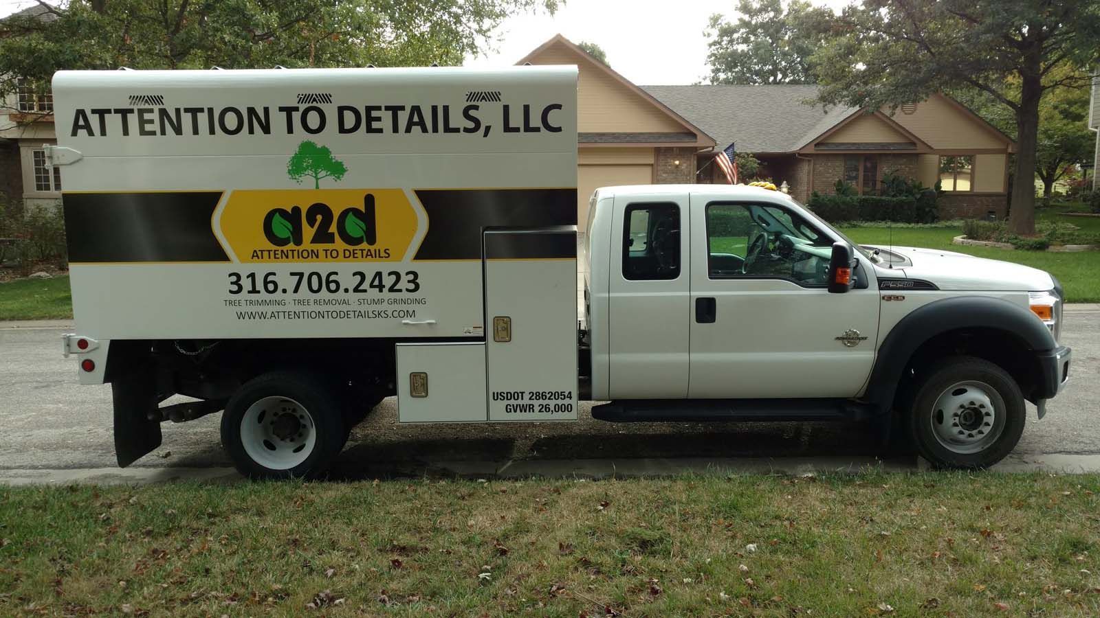 A white truck that says attention to details llc is parked in front of a house
