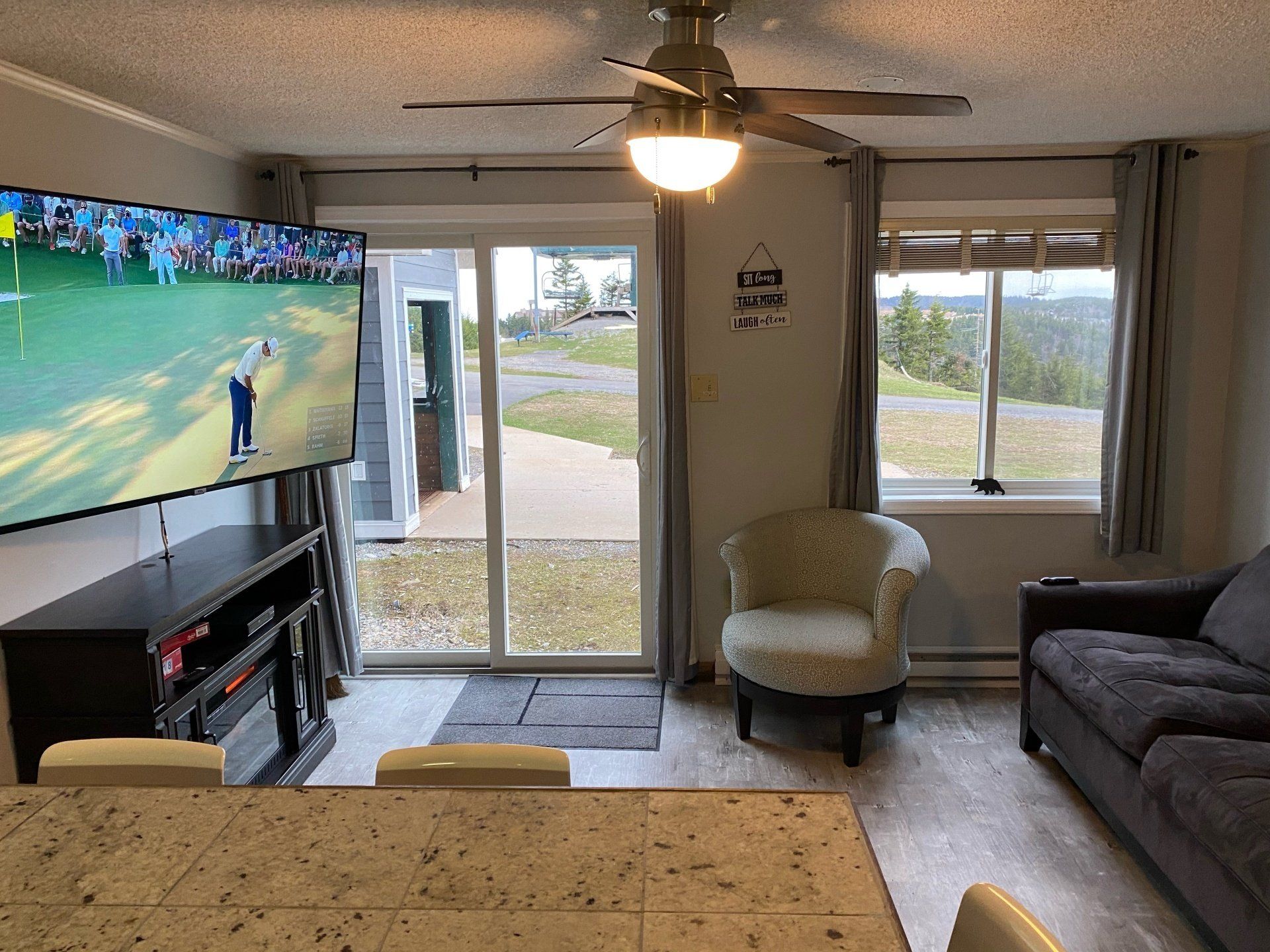 A flat screen tv is hanging on the wall above a fireplace in a living room.