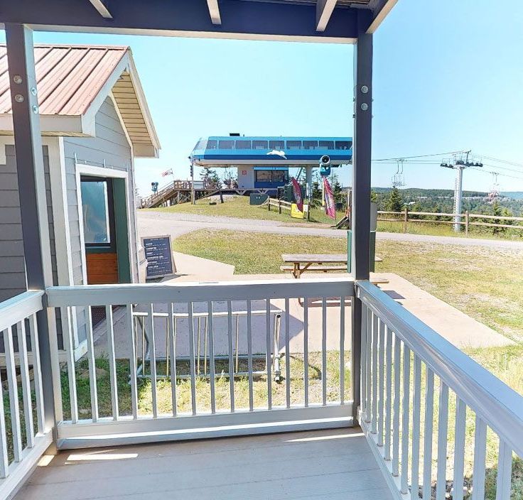 A snowy balcony with a ski lift in the background