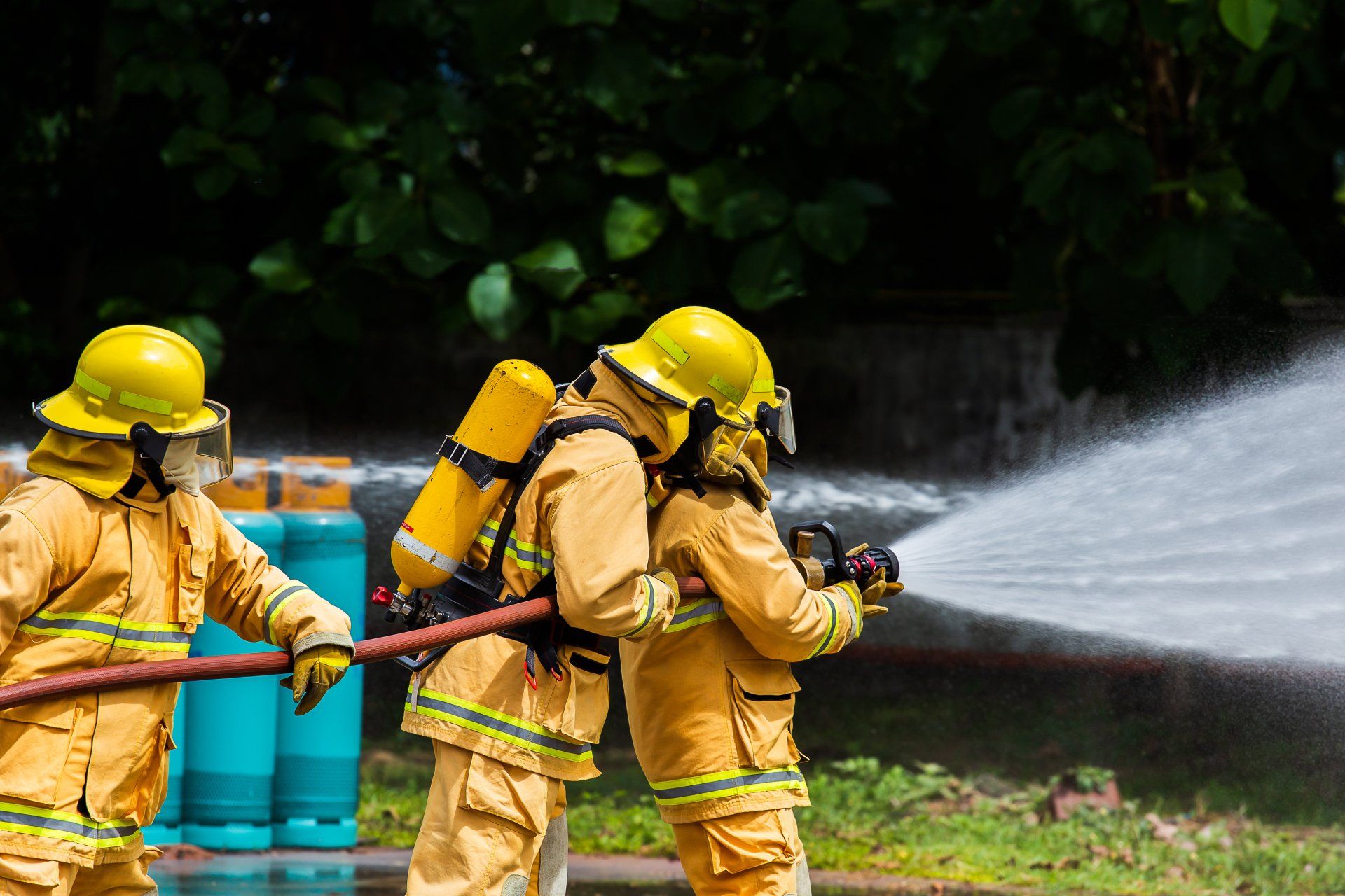 Fire fighters are spraying water from a fire hose.
