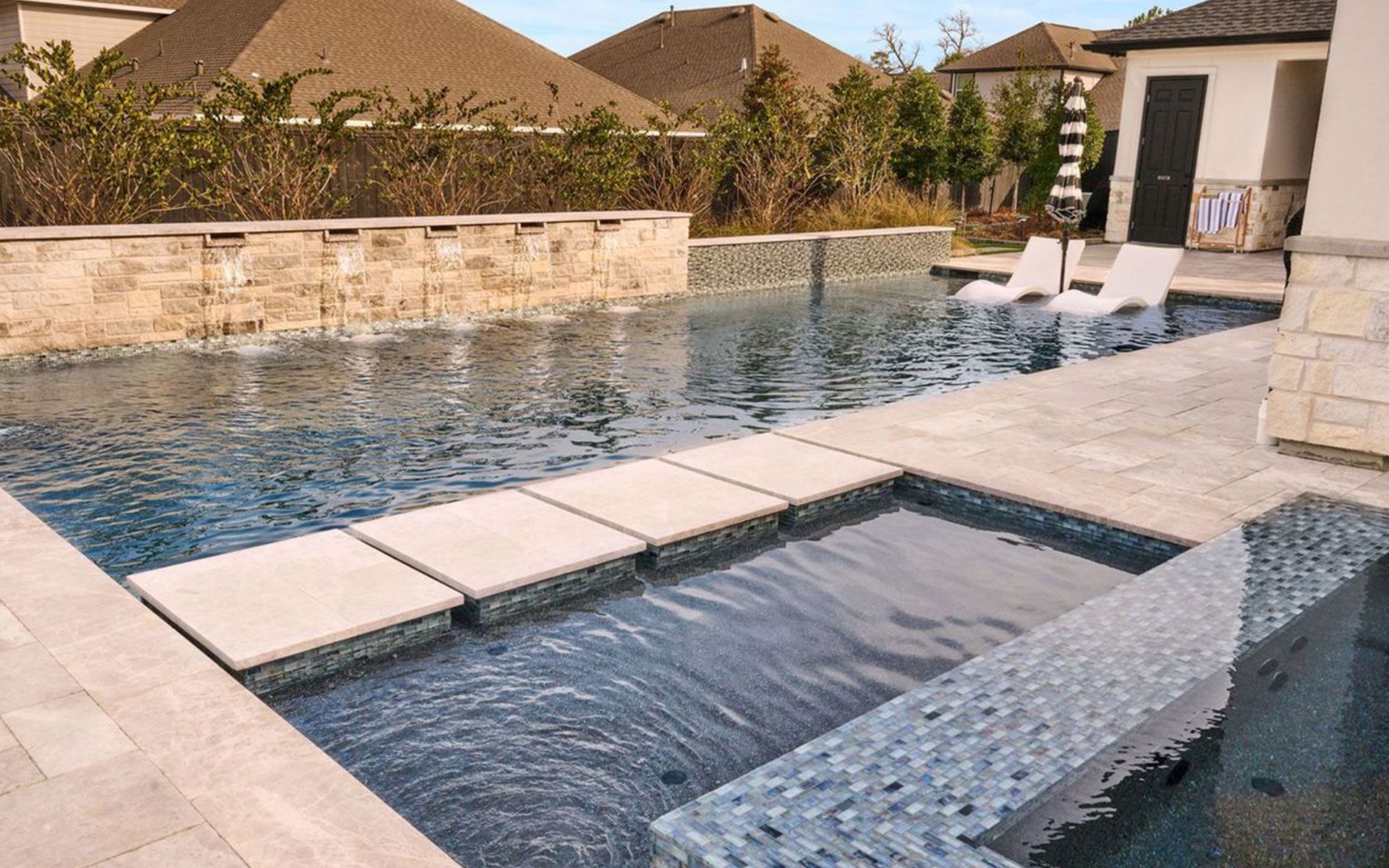 A large swimming pool with a hot tub next to it