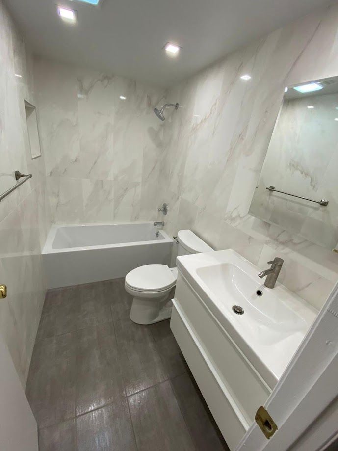 A bathroom with a toilet , sink and bathtub