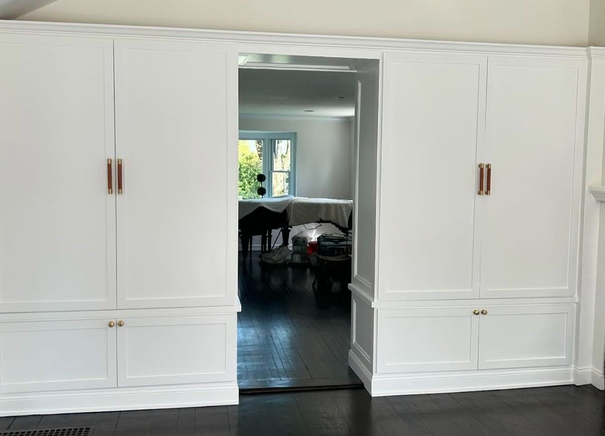 A living room with white cabinets and a door leading to a dining room.