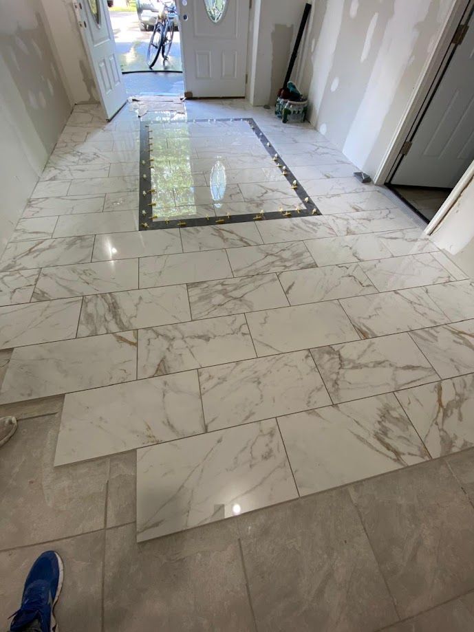 A person is standing on a tiled floor in a hallway.