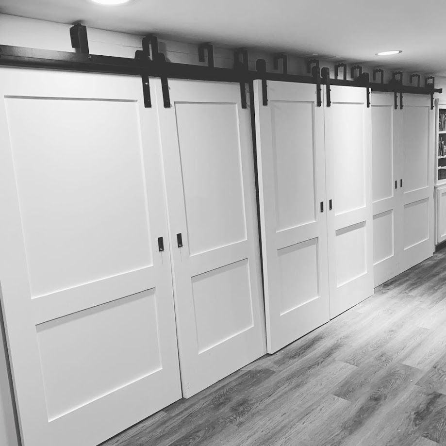 A black and white photo of a hallway with sliding barn doors
