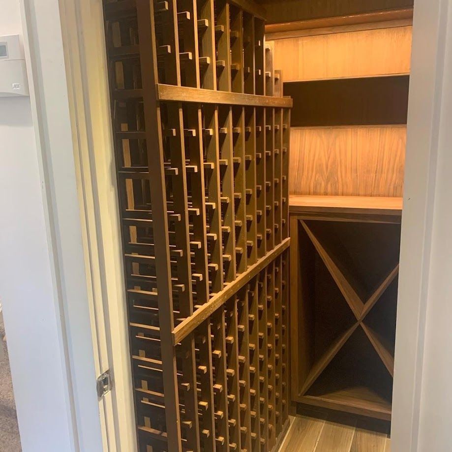 A wooden wine rack is sitting in a room next to a door.
