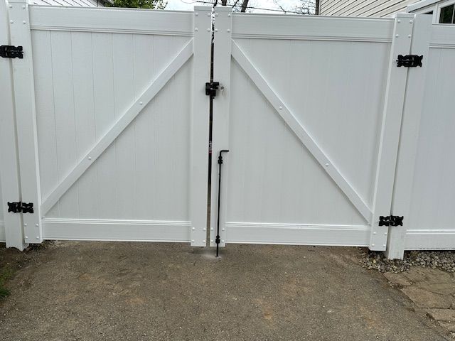A white fence with a black latch on it