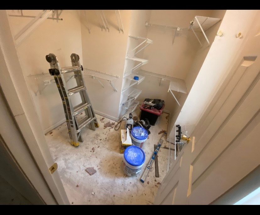 Empty closet with shelves; ladder and tools inside.