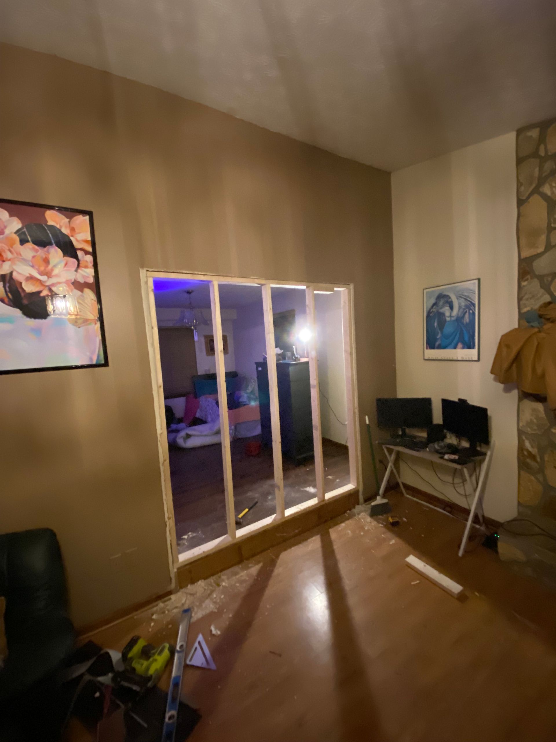 Interior room with a wooden frame built in a wall. Brown walls, hardwood floor.