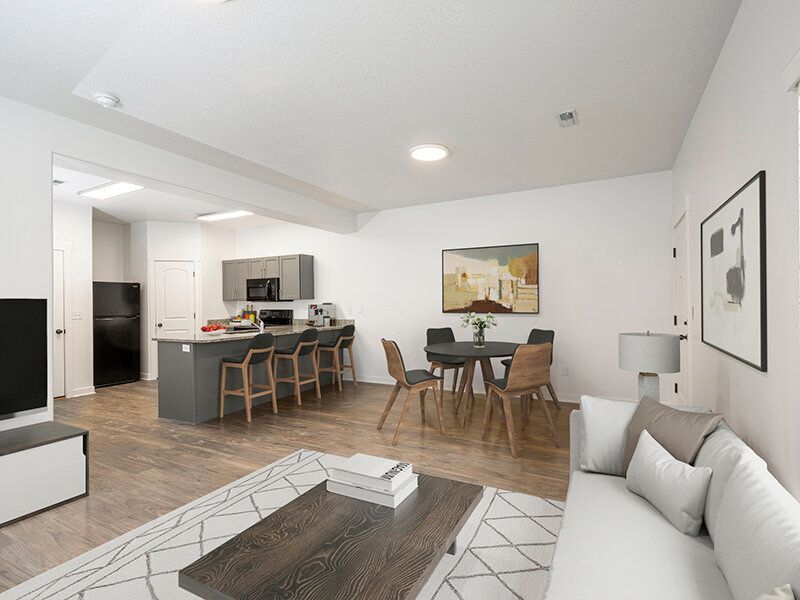 Open-concept living area with a sofa, coffee table, dining table, and kitchen island.