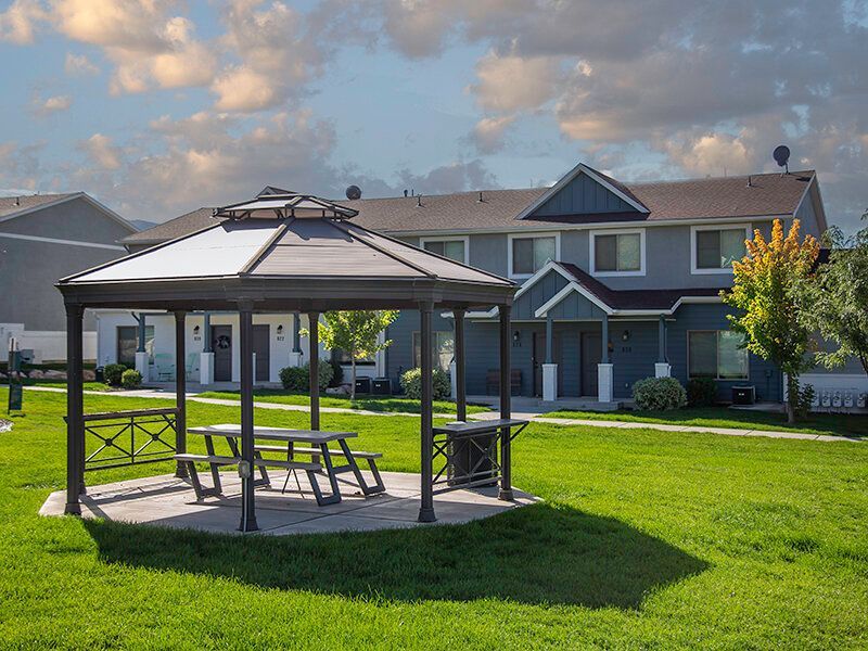 Gazebo with picnic table in a grassy courtyard of an apartment community.