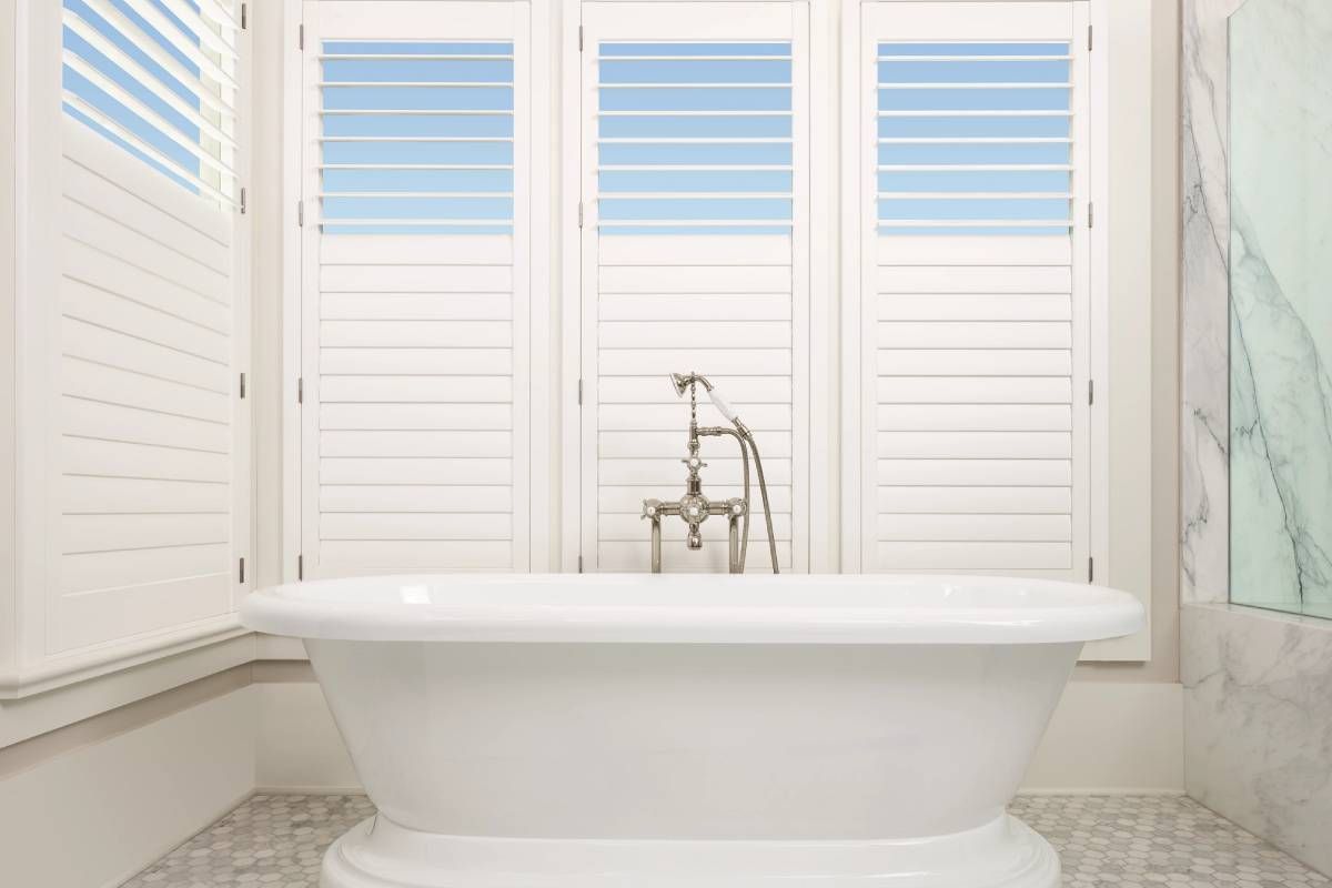 White Interior Shutters and Tub in a Modern Bathroom at Style Savvy Designs near Warrenton, VA