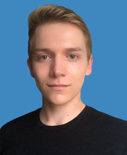 A young man wearing a black shirt is standing in front of a green background.