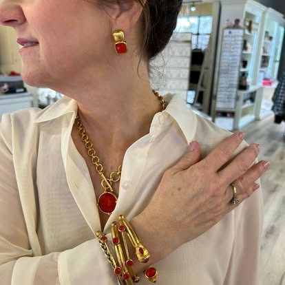 A woman wearing a necklace , bracelet , and earrings.