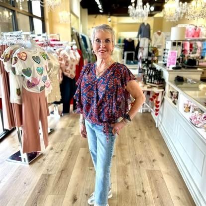 A woman is standing in a clothing store.