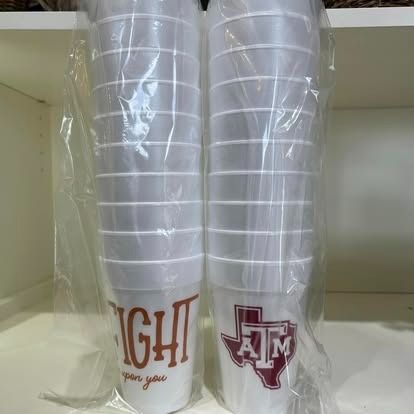 Two plastic cups are stacked on top of each other on a shelf.