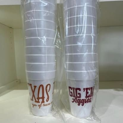 Two plastic cups are stacked on top of each other on a shelf.