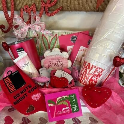 A basket filled with valentine 's day gifts and a gift card.