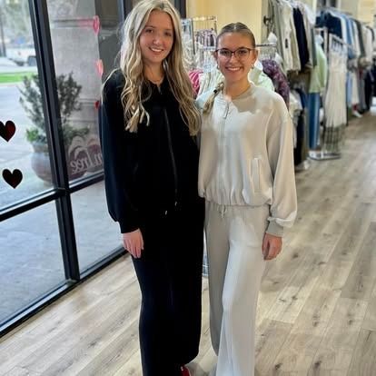 Two women are standing next to each other in a clothing store.