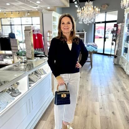 A woman is standing in a store holding a purse.