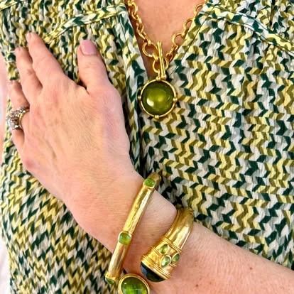 A woman wearing a bracelet and a necklace on her wrist.