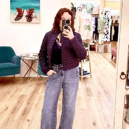 A woman is taking a selfie in front of a mirror in a store.