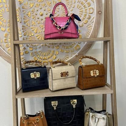 A shelf filled with lots of different types of handbags.