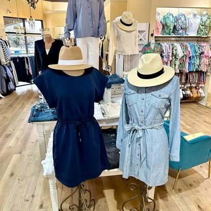 A display of dresses and hats in a clothing store.