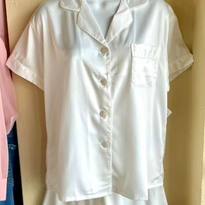 A white pajama set is hanging on a mannequin.