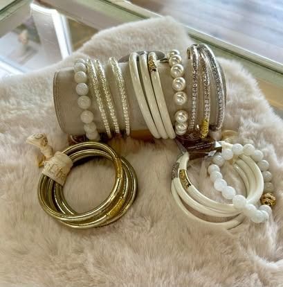 A bunch of bracelets are stacked on top of each other on a table.