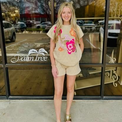 A woman is standing in front of a palm tree store.