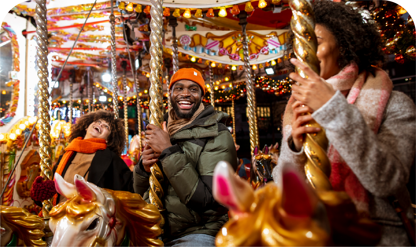 A group of people are riding a merry go round at a carnival.