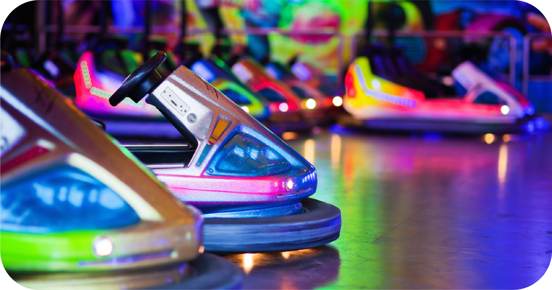 A row of bumper cars are lined up in an amusement park.