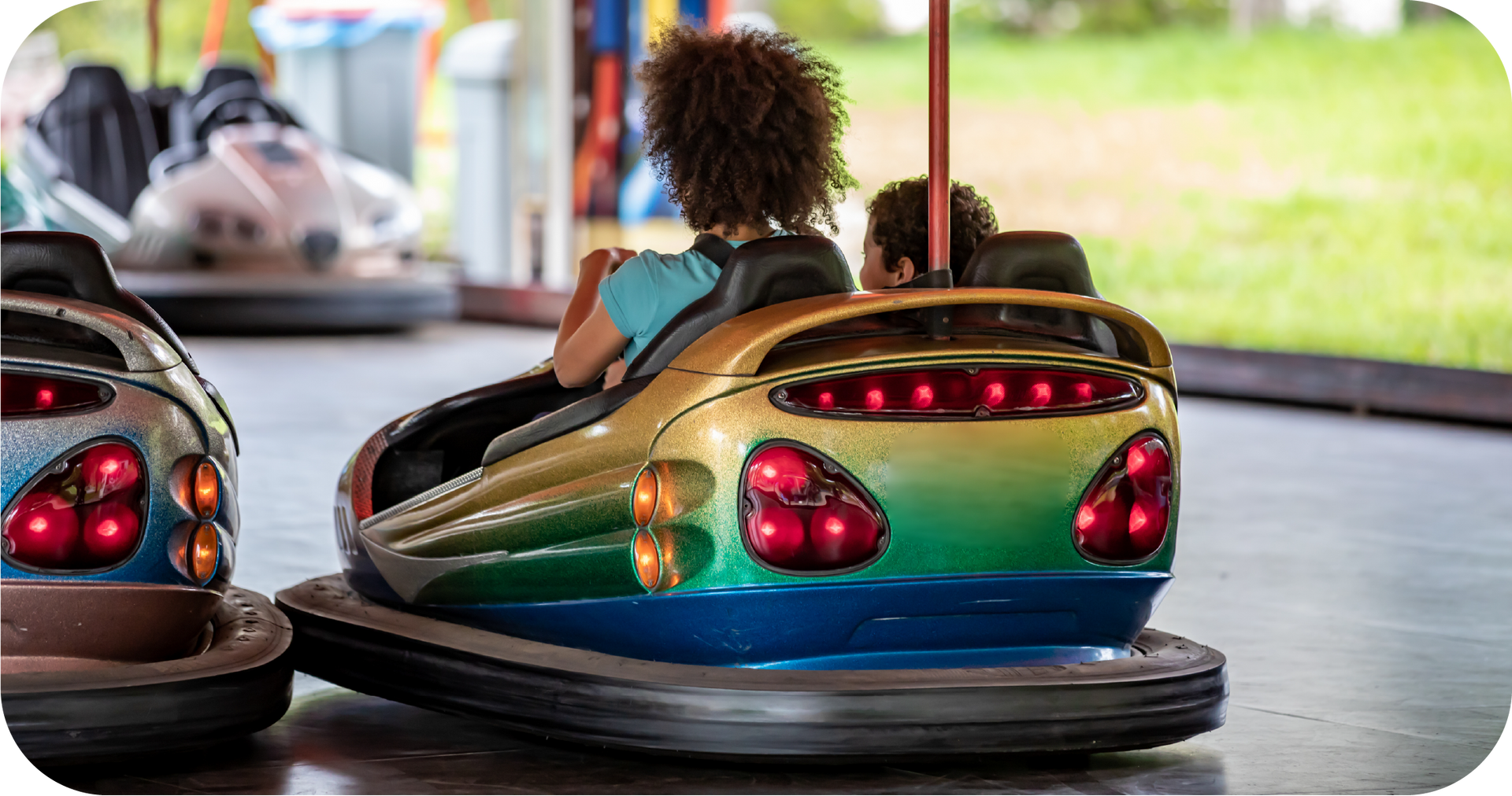 A woman is riding a bumper car at an amusement park.