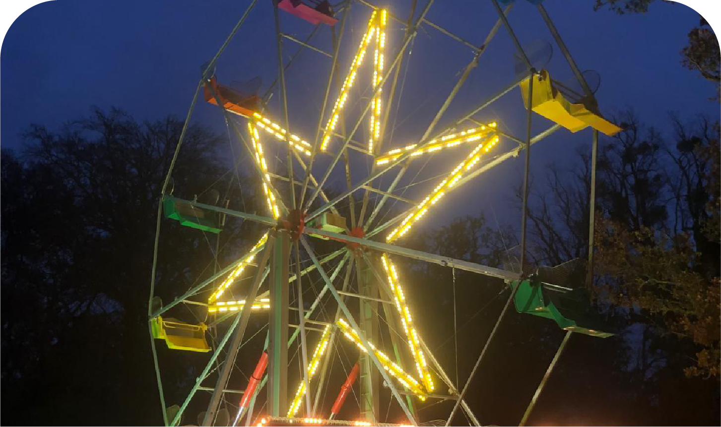 A colorful ferris wheel is lit up at night