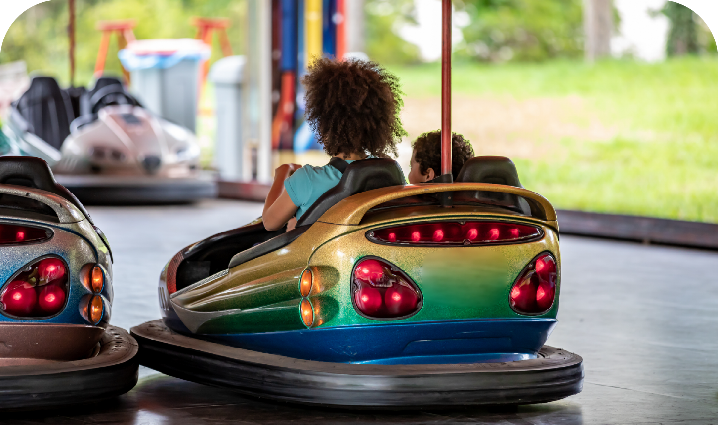 A group of people are riding bumper cars at an amusement park.