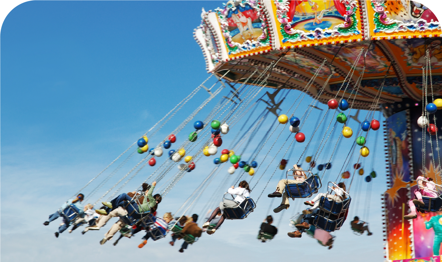 A group of people are riding a merry go round at an amusement park.