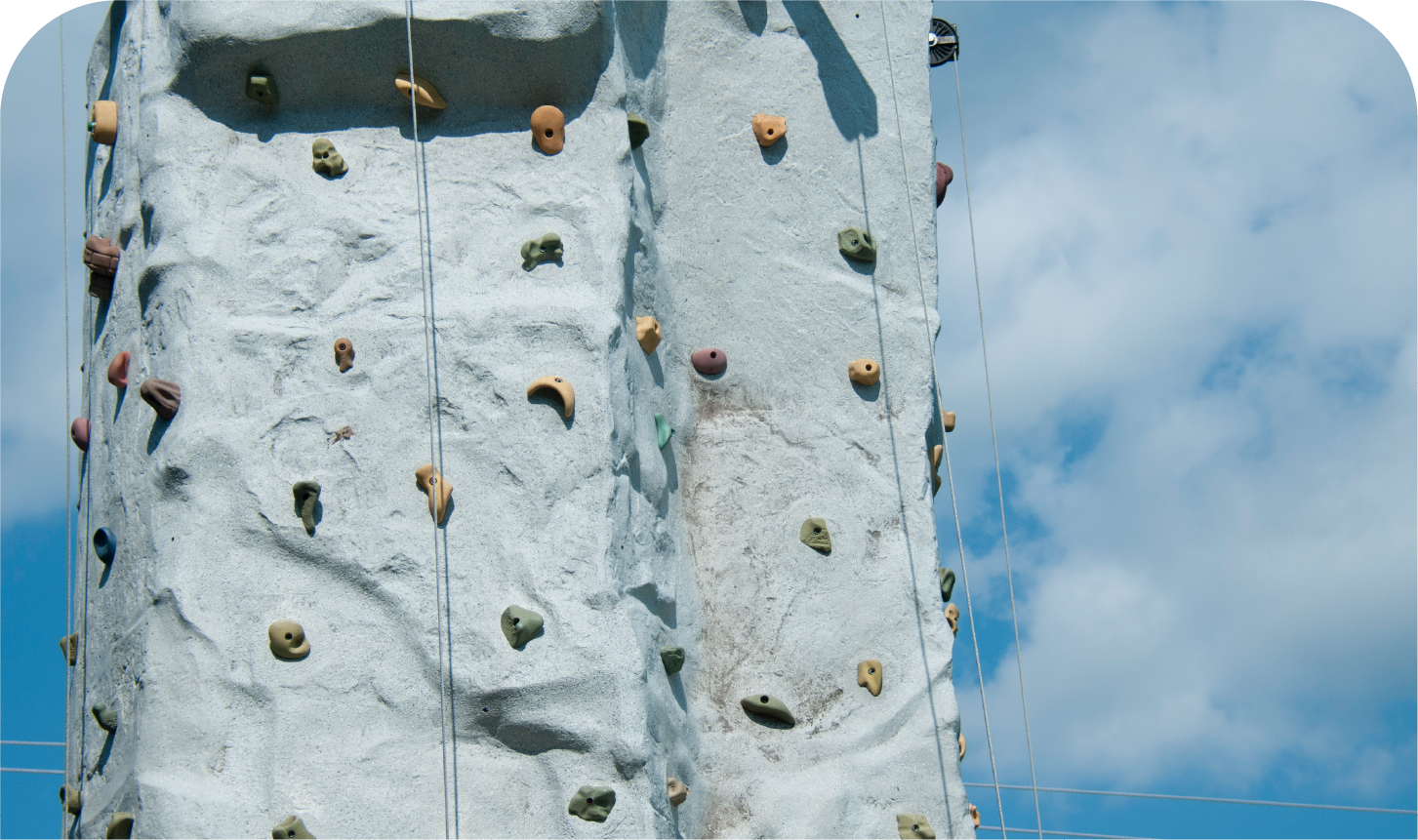 A climbing wall with a blue sky in the background