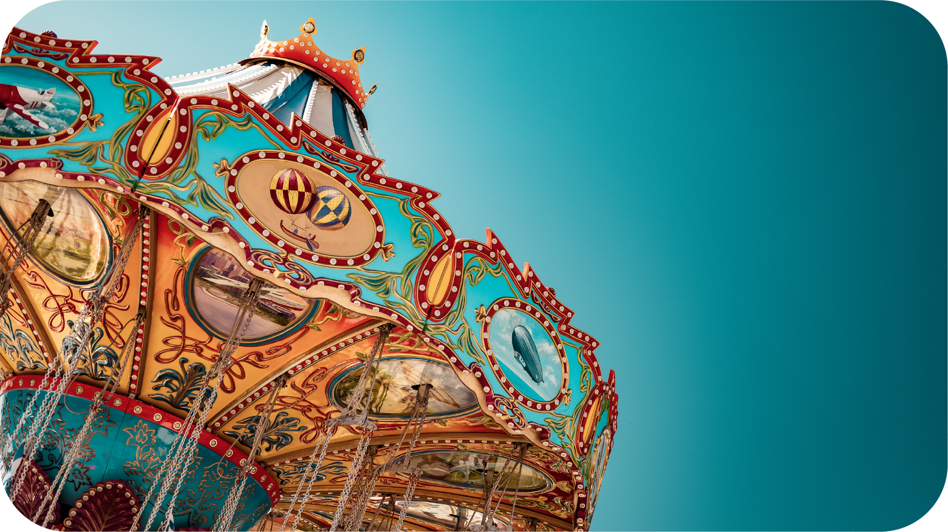 A colorful merry go round is against a blue sky.