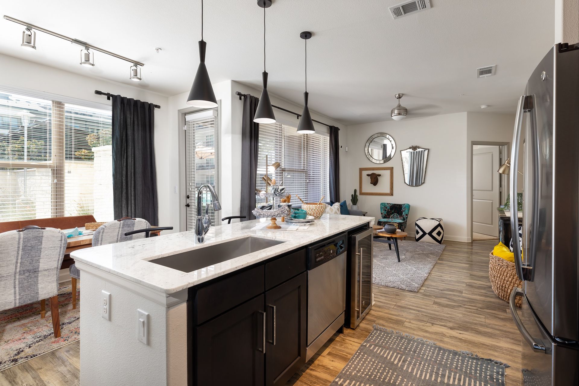 A kitchen with a sink , refrigerator , dishwasher , and stainless steel appliances.