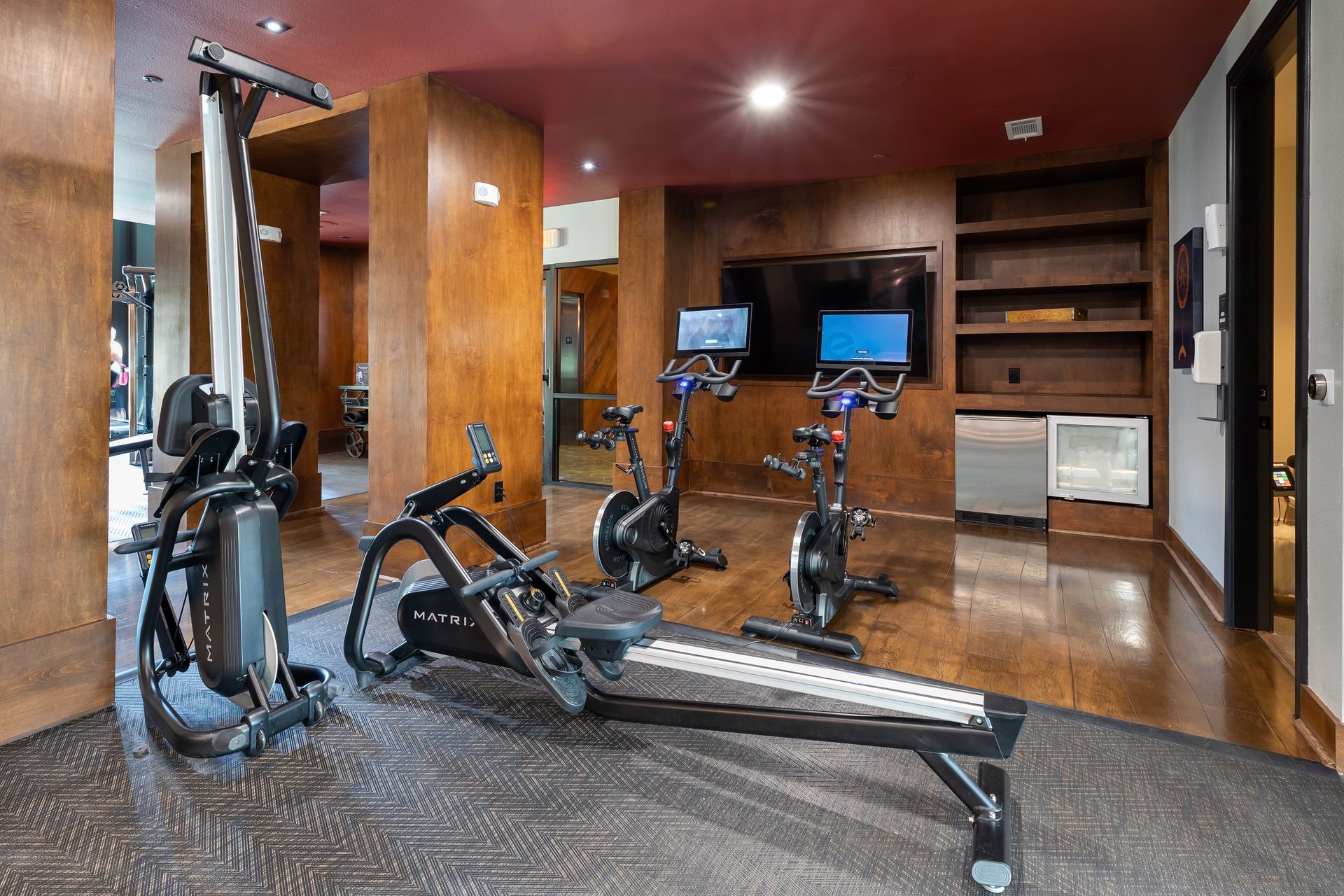 A gym with a lot of exercise equipment and a television.